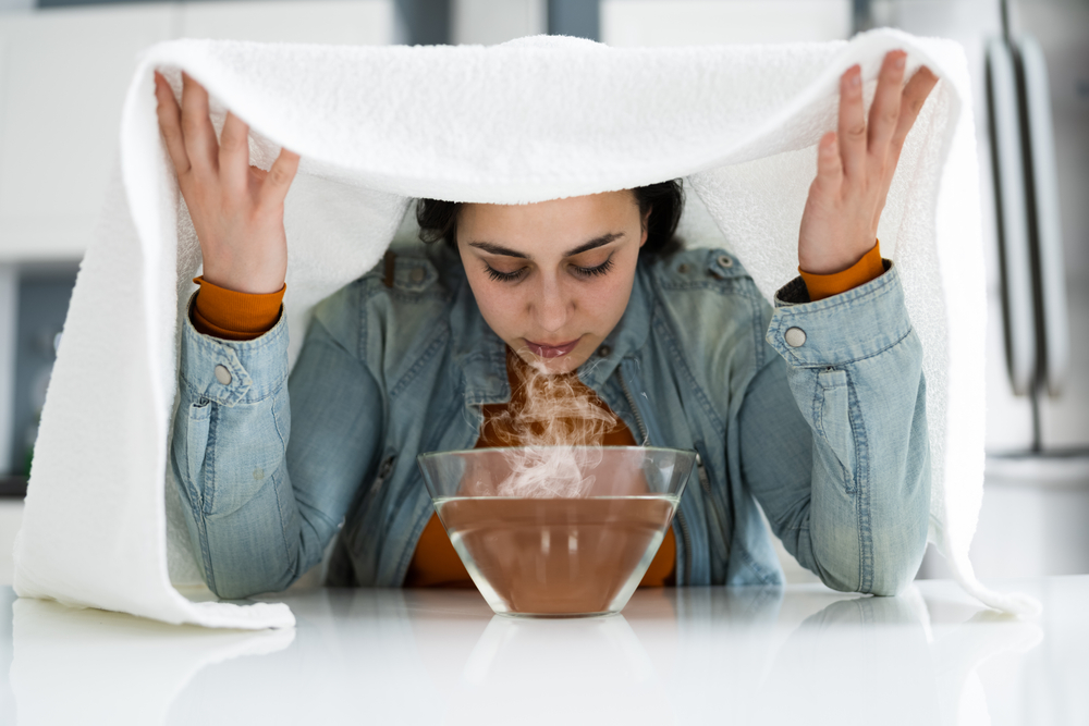 Woman Doing steam healing power inhalation Alternative Herbal Medicine Using Steam Bowl